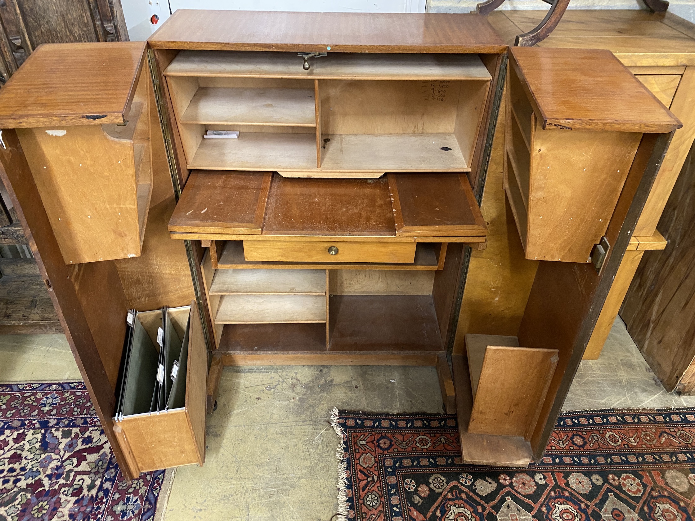 A mid century teak 'magic box' enclosed desk, width 85cm, depth 54cm, height 114cm